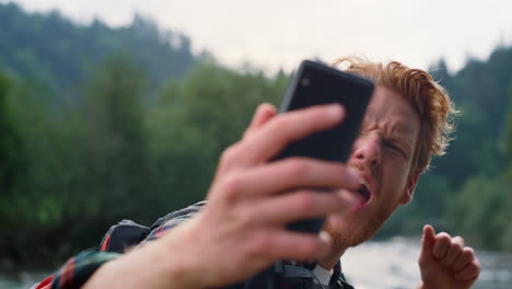 hiker taking selfie on phone in mountain landscape