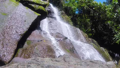 Flowing cascading waterfall over rock face on tropical island of Bougainville, Papua New Guinea