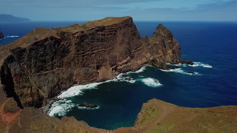 Erleben-Sie-Das-Beruhigende-Geräusch-Der-Wellen,-Die-Sich-Um-Einen-Kleinen-Berg-Brechen,-Der-Ins-Meer-Ragt