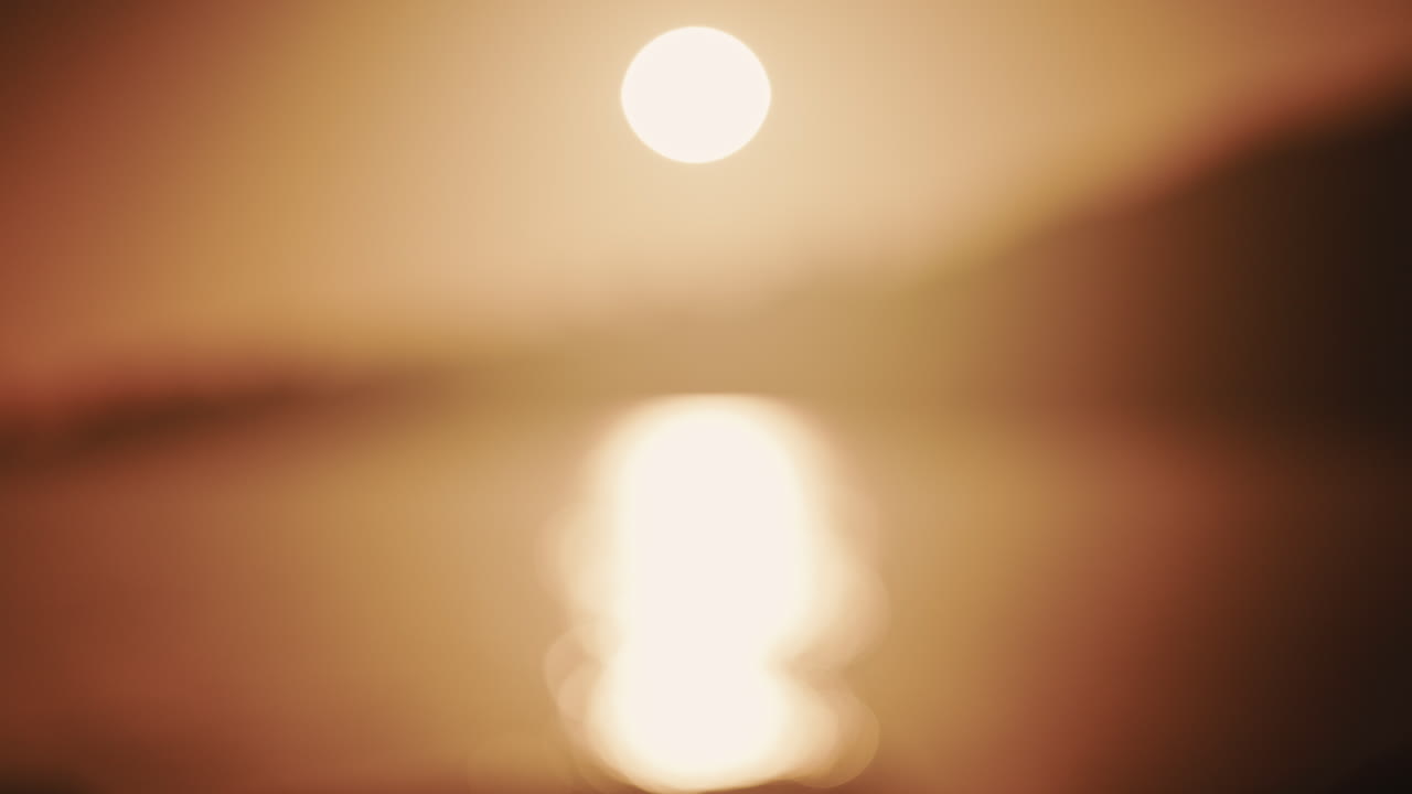 Abstrakte, unscharfe Aufnahme der Sonne und ihrer Spiegelung auf dem Meer