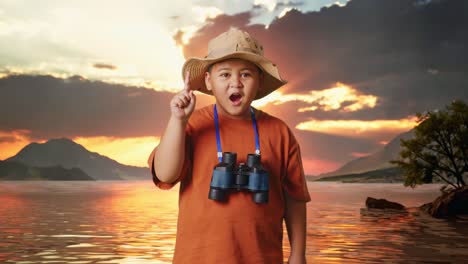 Asian Boy With A Hat And Binoculars Thinking And Looking Around Then Raising His Index Finger At A Lake. Boy Researcher, Travel Tourism Adventure Concept