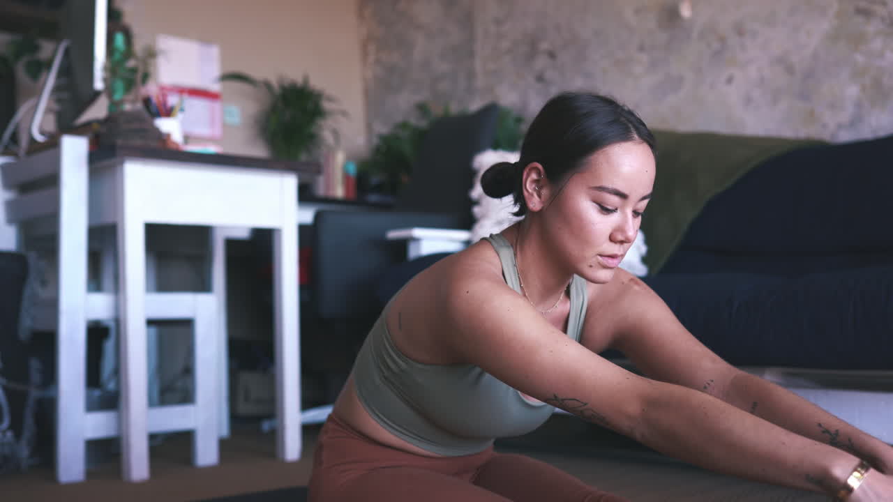 una mujer joven practicando yoga en casa