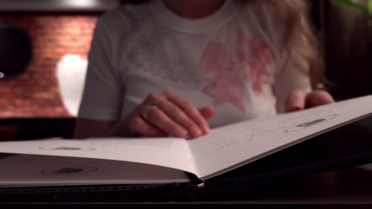 Close up of a woman reading a menu at a restaurant