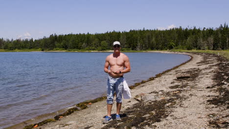 adult, white, shirtless male is standing on a new england beach during late summer, preparing to skip a stone