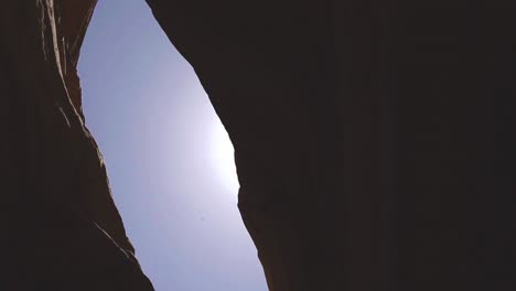 red canyon view from the bottom, sun flare, blue sky, low angle shot
