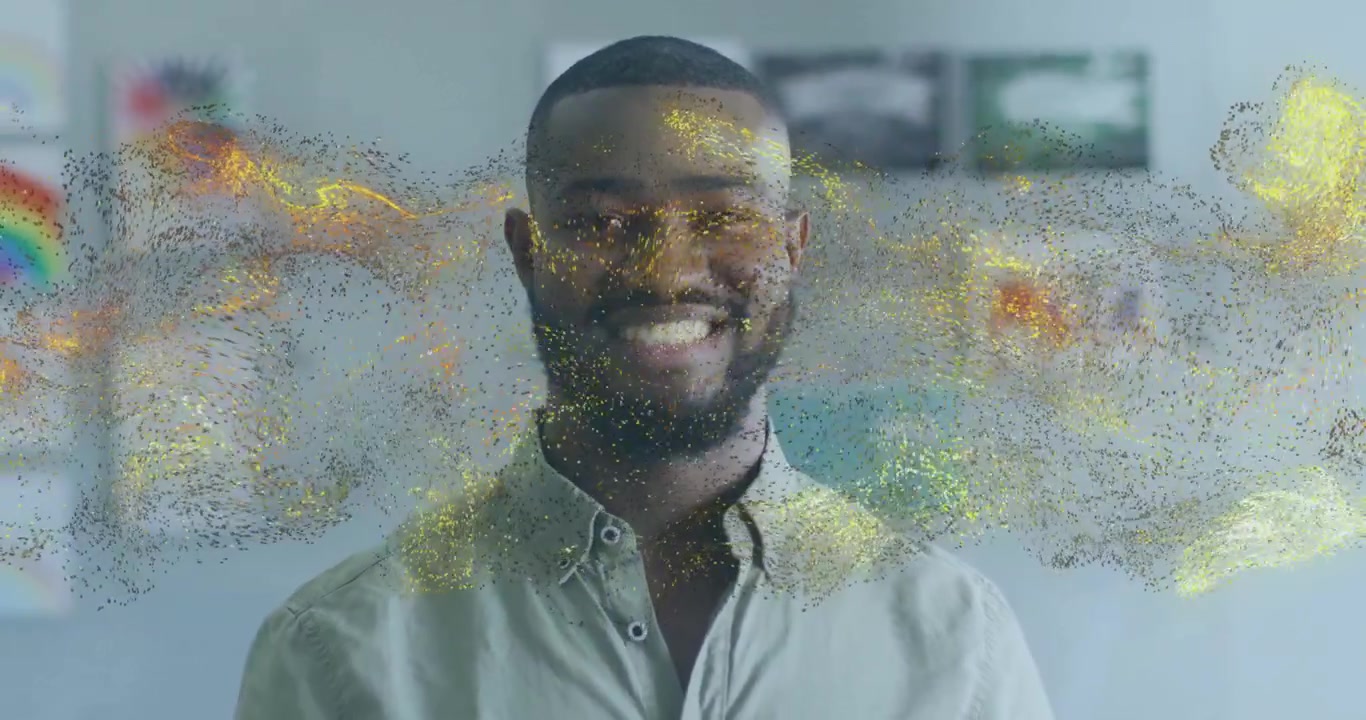 Homme souriant activant un nuage de particules sur son visage, avec une lumière chaude et un arrière-plan artistique flou évoquant la technologie