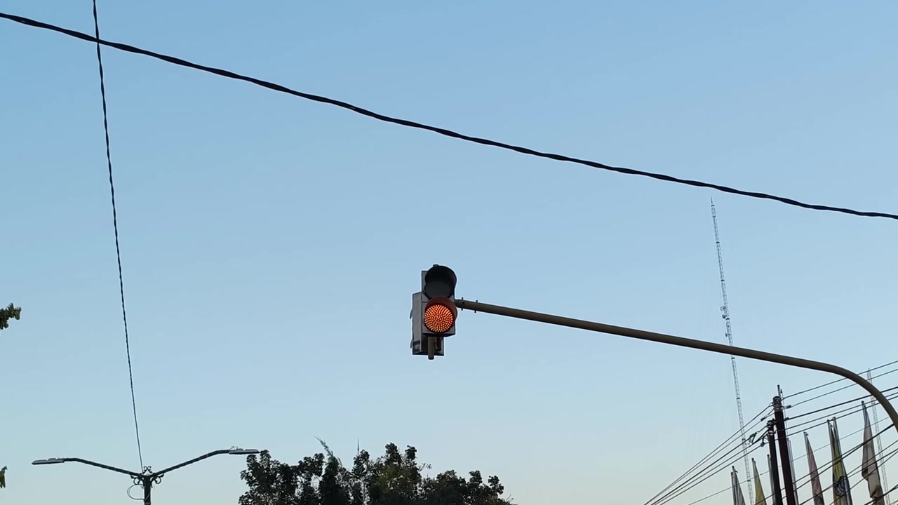 Lampu Lalu Lintas Kuning Berkedip di Bawah Langit Biru Cerah