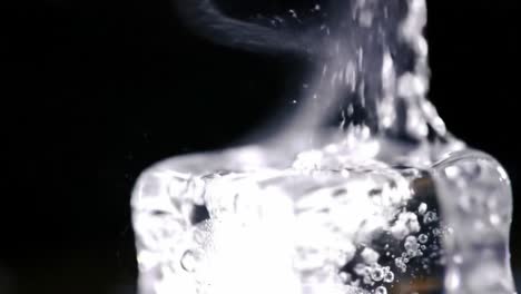 captivating close-up of ice melting with captured air bubbles and intriguing steam emanating in a high-contrast black background