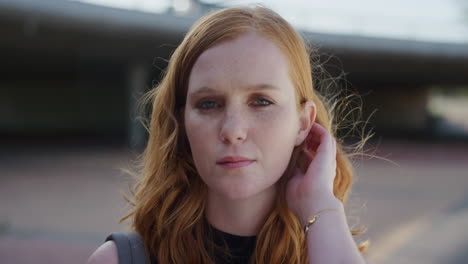 close-up-portrait-beautiful-young-red-head-woman-looking-serious-running-hand-through-hair-confident-independent-female-urban-background