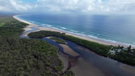 Pertenencia-Al-Arroyo-Y-La-Playa-En-Byron-Bay,-Nueva-Gales-Del-Sur,-Australia---Toma-Aérea-De-Un-Drone