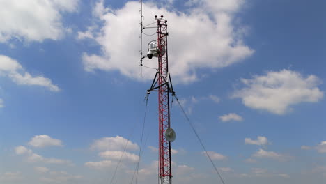 capturing the towering communication structure against a dramatic blue sky.