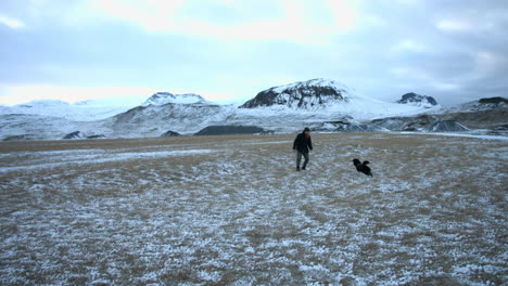 stable shot of owner playing with his pet during a winter day
