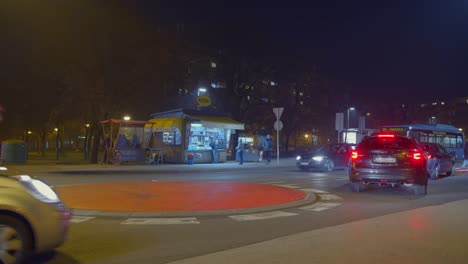 Tráfico-Nocturno-De-La-Ciudad-De-Coches-En-Una-Rotonda