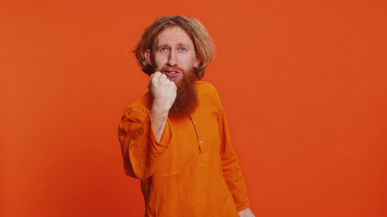 Aggressive angry Caucasian man trying to fight at camera, shaking fist, boxing, punishment, threaten