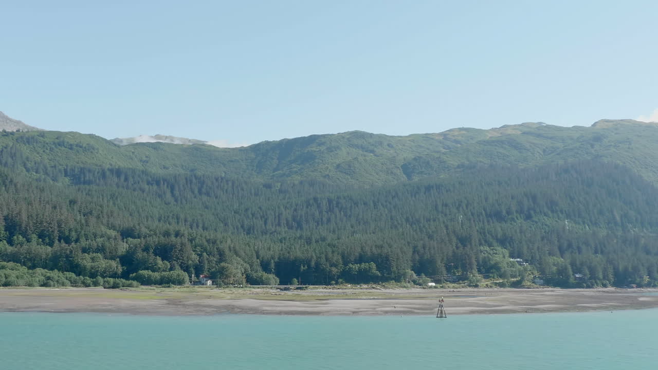 알래스카 주 주네우 해변의 도리 해변과 숲으로 인 산이 배경입니다.