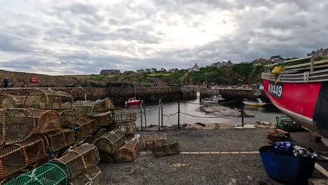 fishing boat and traps at crail, scotland pier