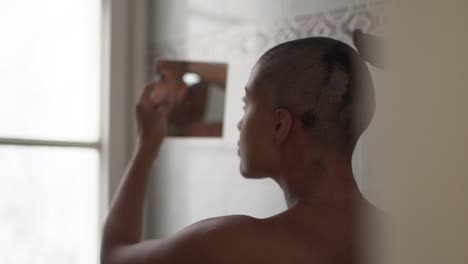 black woman trimming hair at home