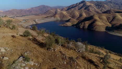 4k-Lake-reveal-from-over-a-mountain-with-a-slight-dolly-zoom-effect-to-the-mountains-in-the-background