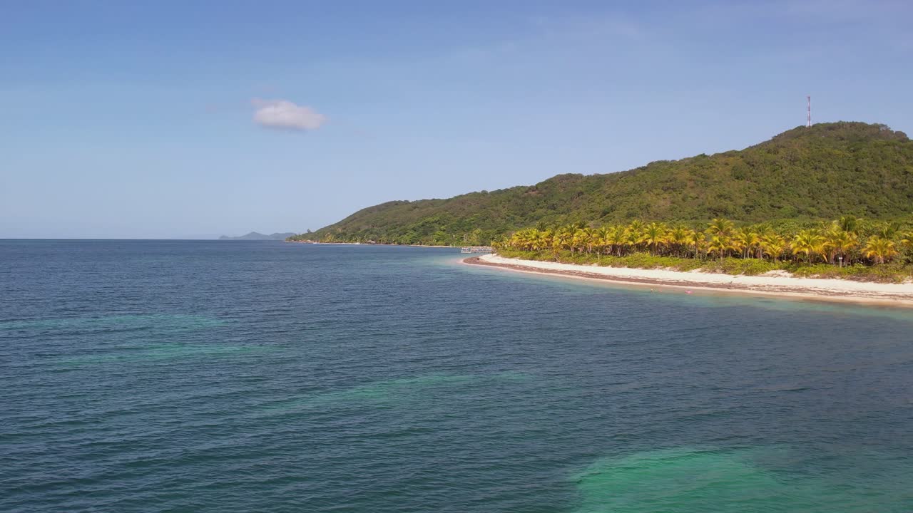 vista aérea de la playa tropical de arena blanca y agua de mar turquesa clara con pequeñas olas y bosque de palmeras