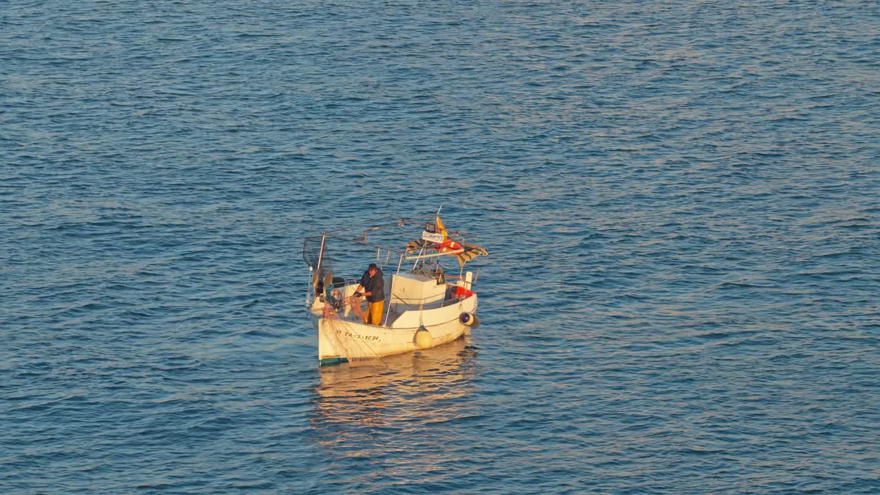 Pescatore su una piccola barca da pesca all'alba