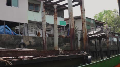 poor local homes by the dirty canal in bangkok. slow motion.