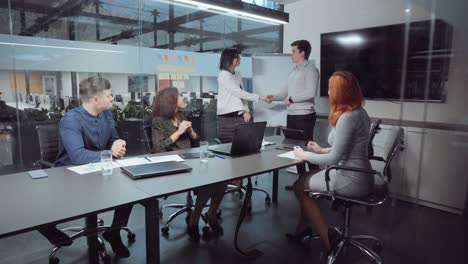 business partners shaking hands after making deal in office