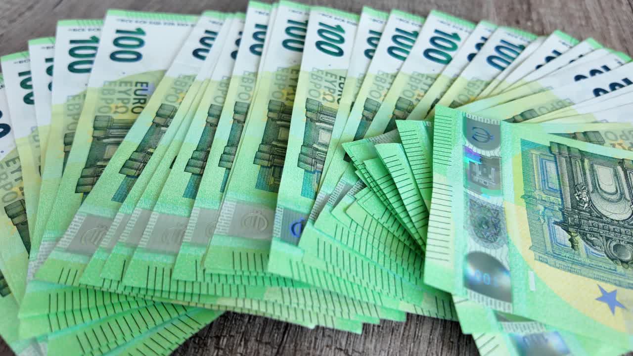los billetes de euro desplegados se extienden sobre la mesa, en cámara lenta