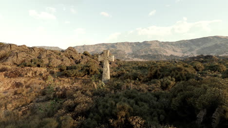 cruz de piedra en un paisaje desértico