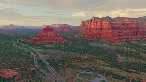 una panorámica aérea cinematográfica sobre la carretera en sedona, arizona, el desierto de alpenglow en red rock