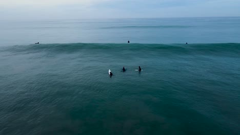 early-morning,-beach-view,-surfers-in-the-water
