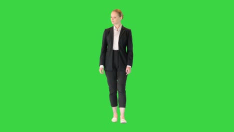 young woman walking through museum or exhibition looking to the sides on a green screen, chroma key