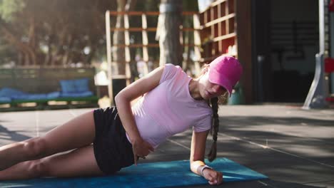woman doing side plank exercise outdoors