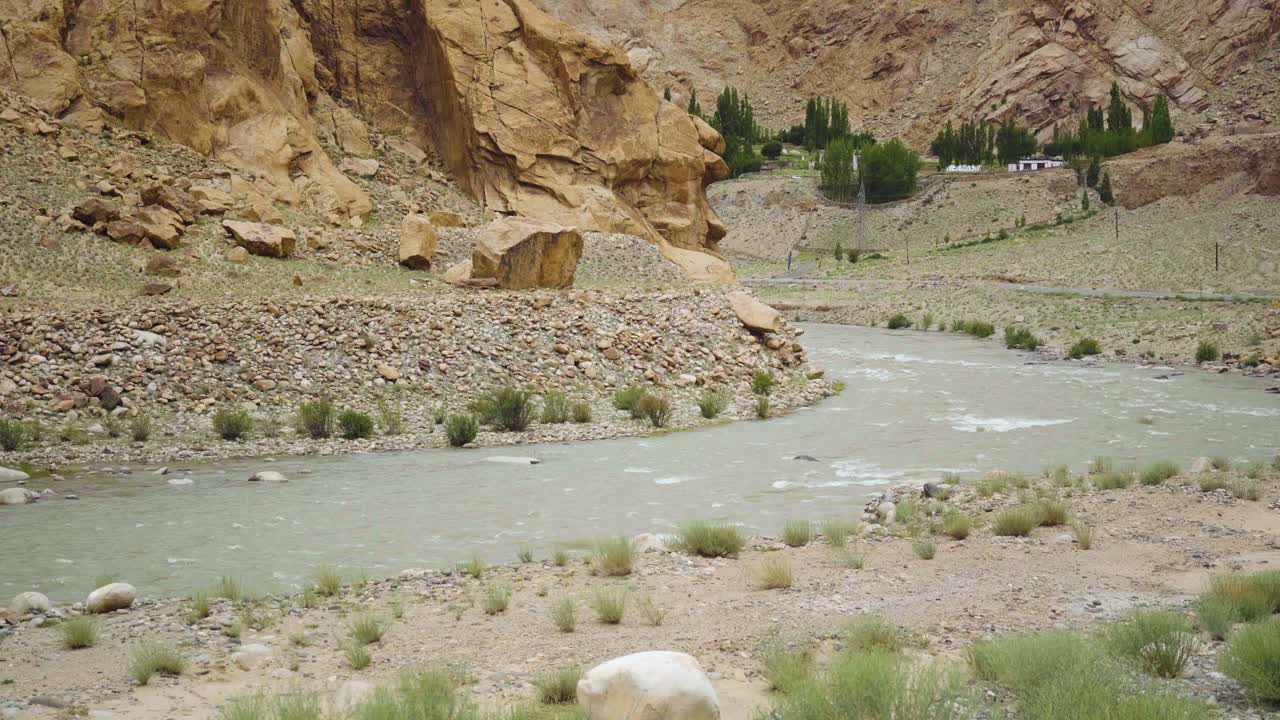 pan shot del río indo que fluye a través del paisaje montañoso del himalaya en la ruta de leh hanle en ladakh, india