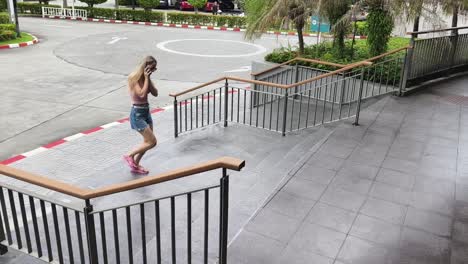woman walking up stairs while talking on the phone