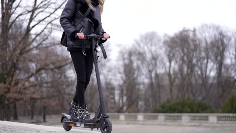 woman riding an electric scooter in a park