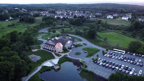 rotating drone view of a banquet house for celebrations and weddings, surrounded by green land and trees