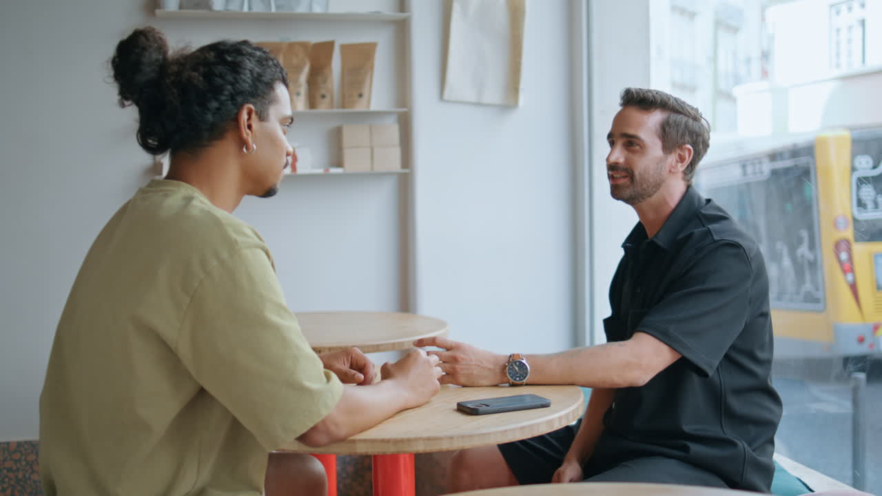 dos amigos hablando en un café en el fin de semana pausa para el café de cerca. reunión de pareja masculina