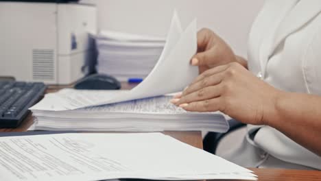 mujer de negocios en traje formal blanco trabajando con documentos en la oficina.