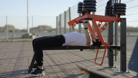 man doing chest press exercise outdoors