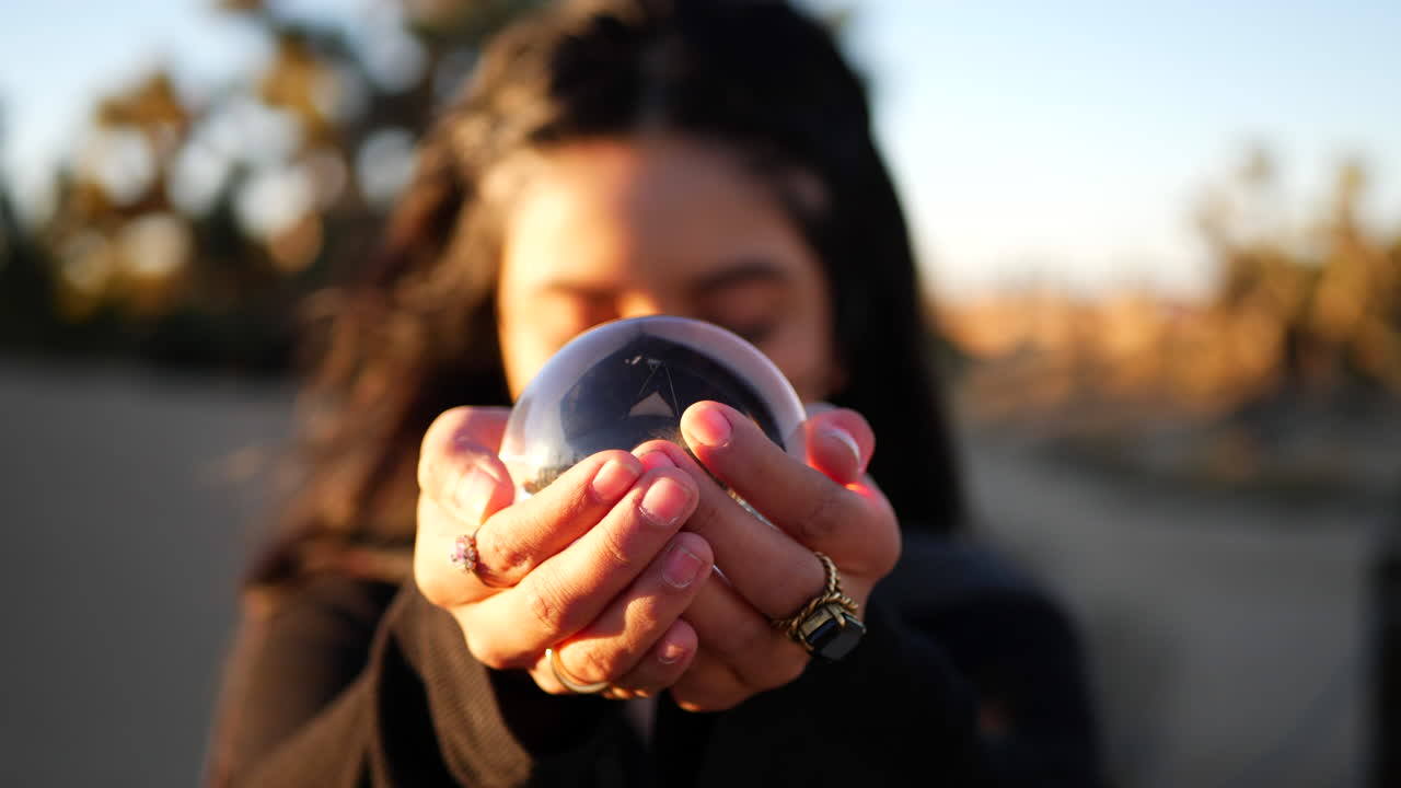 una hermosa bruja en un mundo de cuento de hadas de fantasía sosteniendo una bola de cristal mágica en sus manos mientras lanza un hechizo o predice el futuro