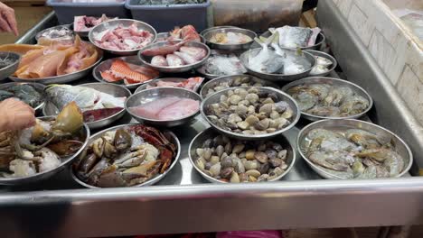 freshness of raw seafood displays neatly on the steel plates in the market in singapore