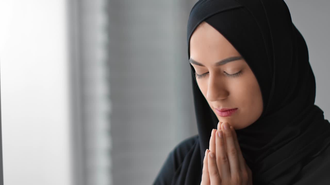 Closeup Muslim female in black hijab praying tranquil face expression. Shot with RED camera in 4K