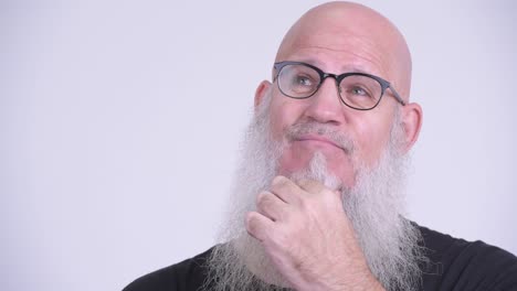 face of happy mature bald man with long gray beard thinking