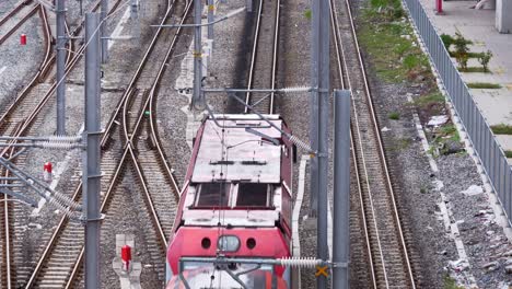 View-from-the-top-of-a-train-coming-from-the-top-middle-to-the-bottom-of-the-frame,-passing-by-Bang-Sue-train-station-in-Bangkok,-Thailand