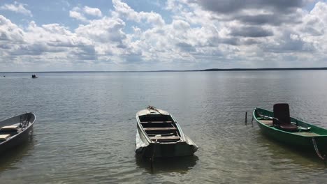 sunny weather on a freshwater lake. on the waves rock boats. in the blue sky lush clouds.