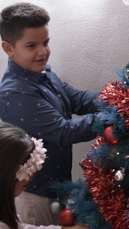 two happy kids decorating the christmas tree at home
