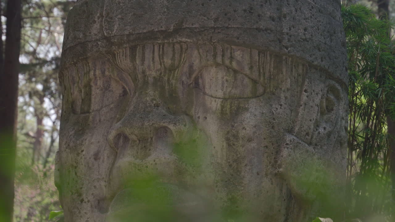 una antigua estatua maya tallada en piedra y encontrada en una selva tropical