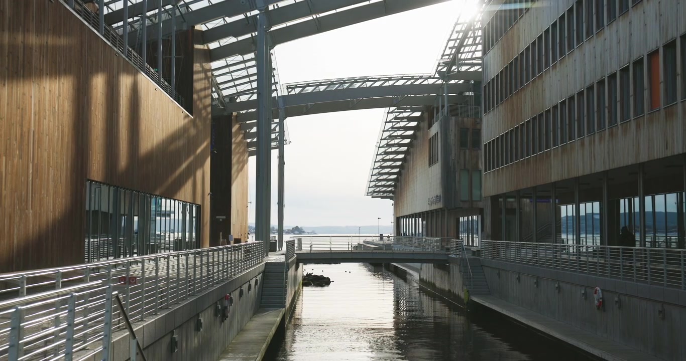 Bridge over canal by Astrup Fearnley museum entrance in sunlight; slide