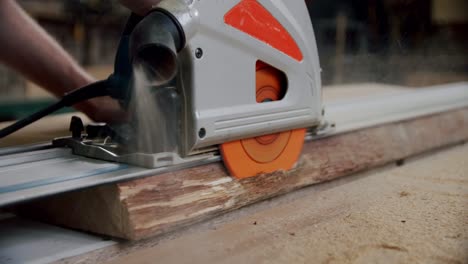 slow motion. the master cuts a wooden board with a circular saw in the woodworking workshop of a small furniture manufacturer. v2