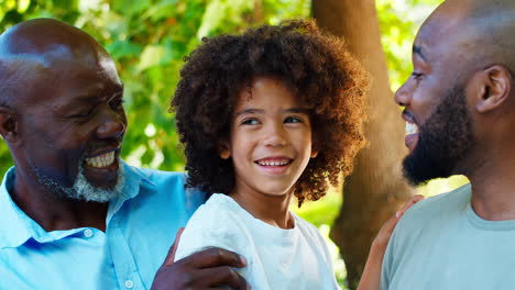 portrait of smiling multi-generation male family in garden together
